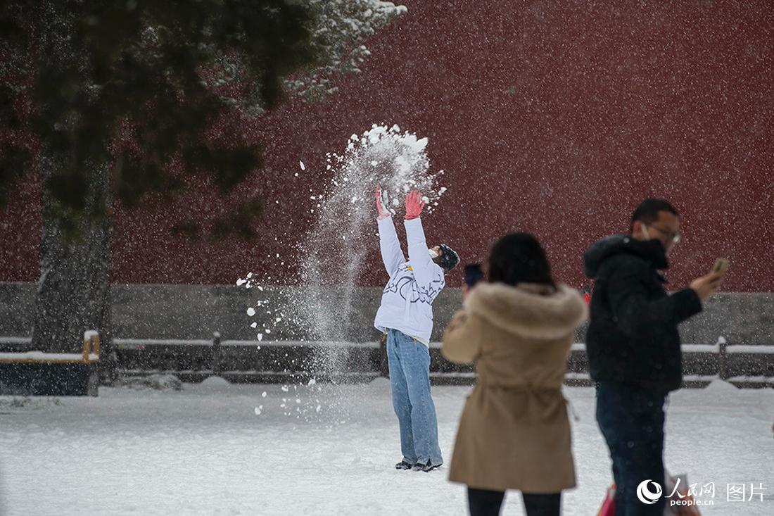 2月13日，在北京景山公园，游客在雪中撒欢。人民网记者翁奇羽摄