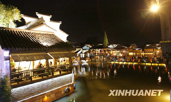 4月26日,游客们在乌镇西栅景区欣赏夜景。