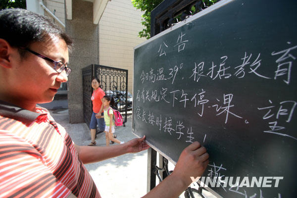 6月24日，一名郑州市民在街头用报纸遮挡烈日。